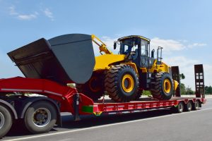 Agricultural tractor secured on a specialized transport trailer