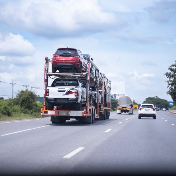 Open car carrier transporting vehicles on a highway