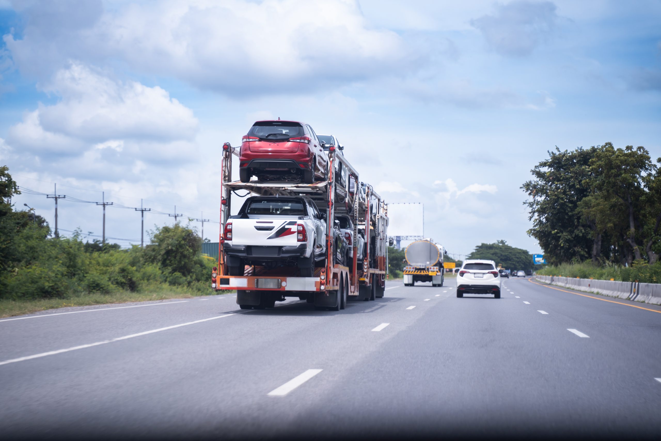 Open car carrier transporting vehicles on a highway