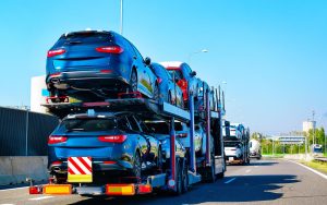 Loaded open car carrier traveling on a roadway