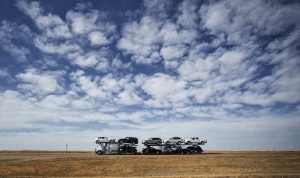 Car carrier traveling through a wide open landscape