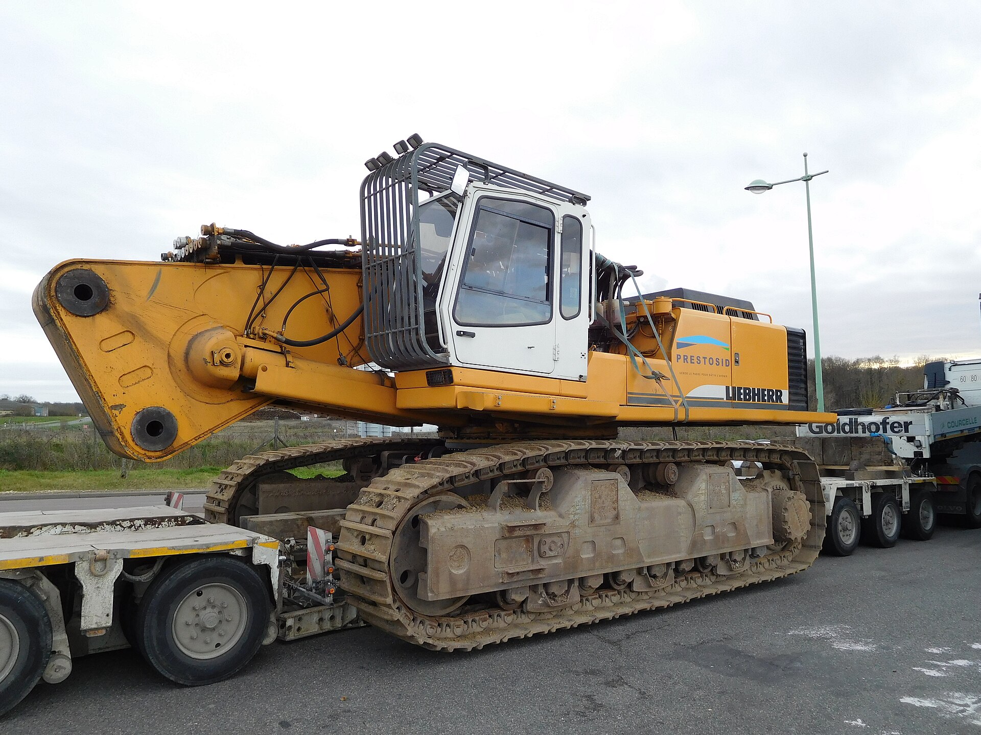 Large tracked excavator secured on a multi-axle lowboy trailer