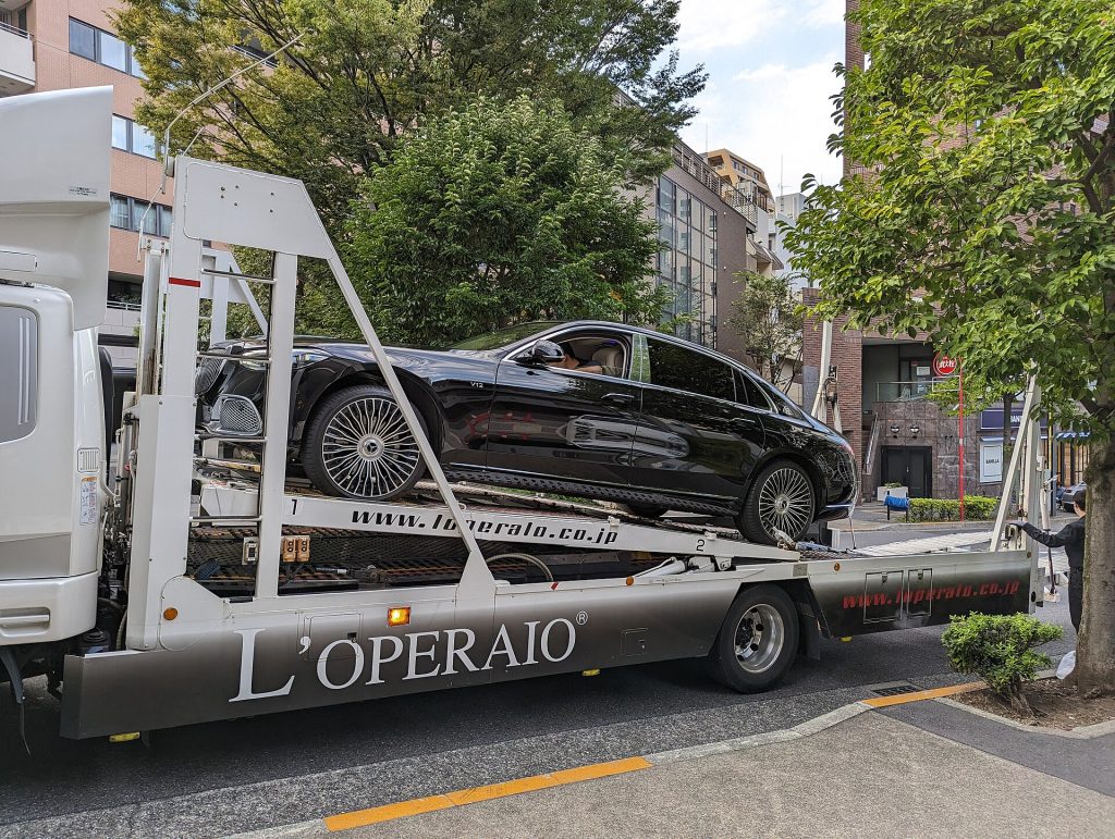 Luxury car being loaded onto an auto transport carrier