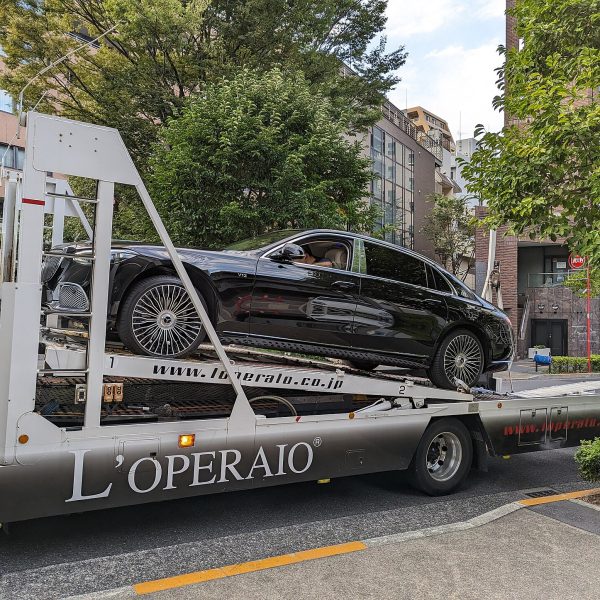 Luxury car being loaded onto an auto transport carrier