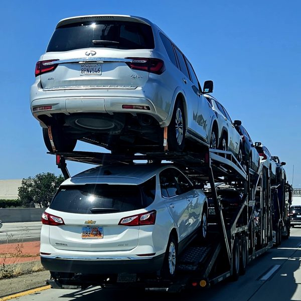 Loaded open car carrier transporting vehicles on a highway