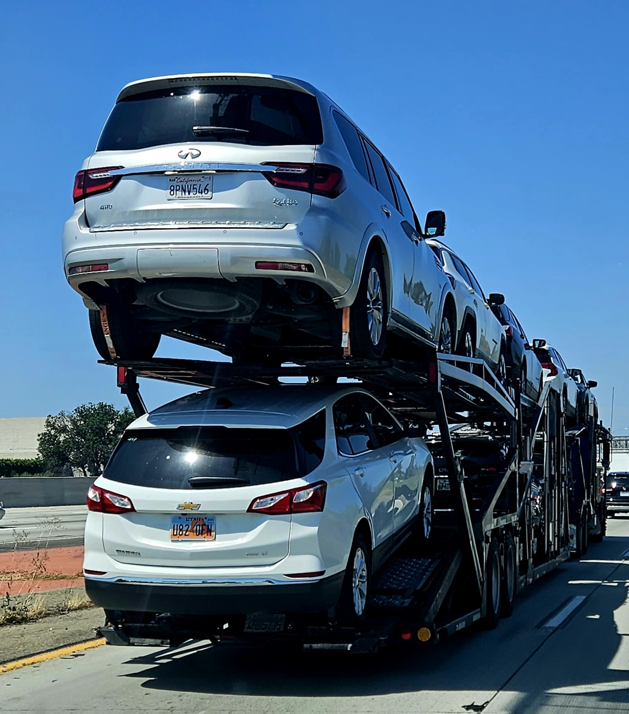 Loaded open car carrier transporting vehicles on a highway
