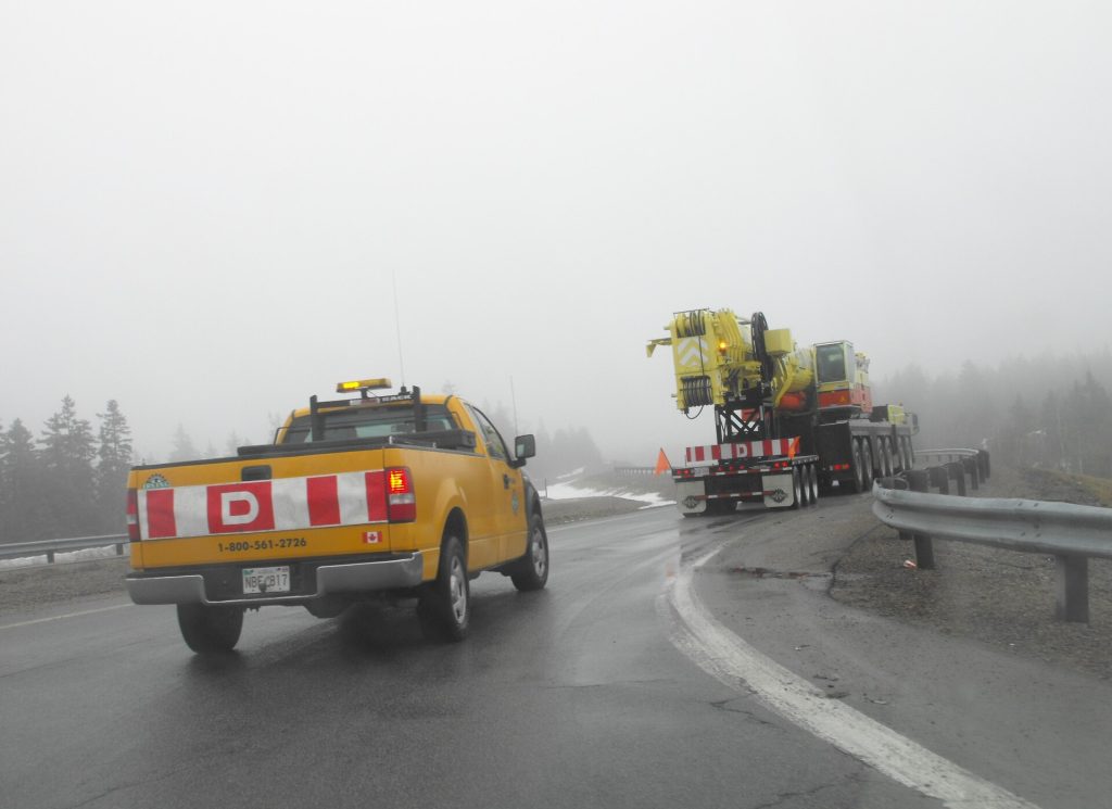Wide-load truck traveling with an escort vehicle