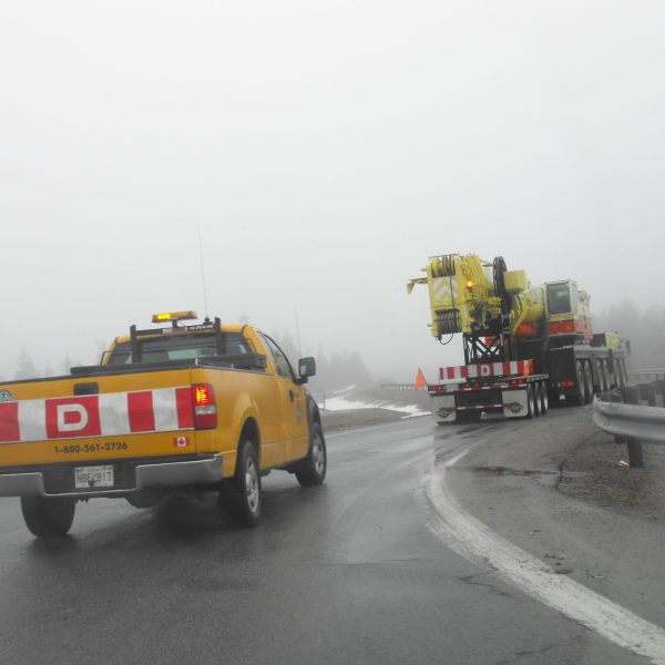 Wide-load truck traveling with an escort vehicle